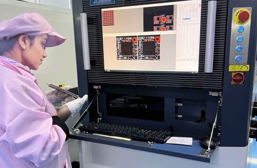 Cleanroom operator reviewing automated optical inspection results on a circuit board assembly
